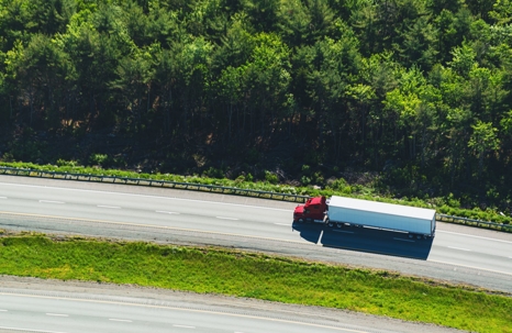 Semi-truck driving on a lonely highway during the day