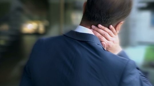Man holding the back of his neck