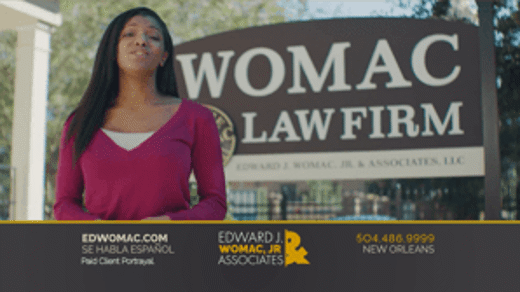 client in front of the womac law firm sign